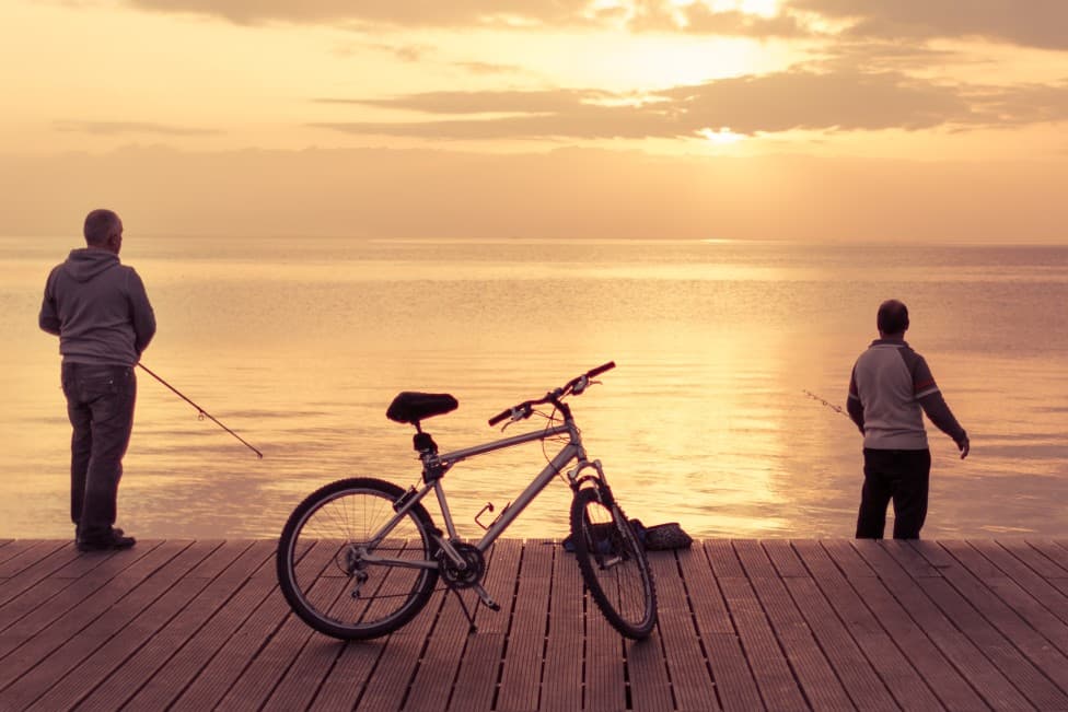 Two men fishing from a dock.