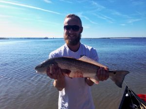 Man wearing sunglasses while holding a fish